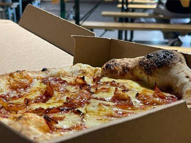 Lezzetli pastırmalı peynirli pizzayı karton kutuya koy.
