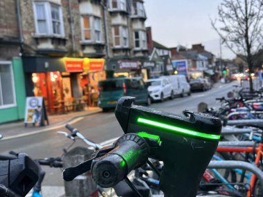 Şehir caddesinde yeşil parlayan elektrikli scooter servisini paylaşmak