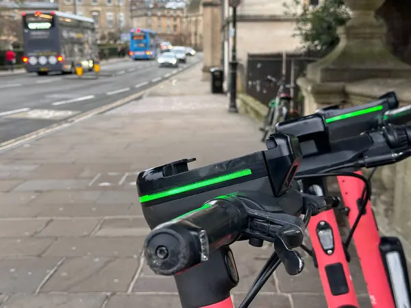 Arka planda şehir caddesi, yeşil parlayan elektrikli scooter kulplarının kapatılması