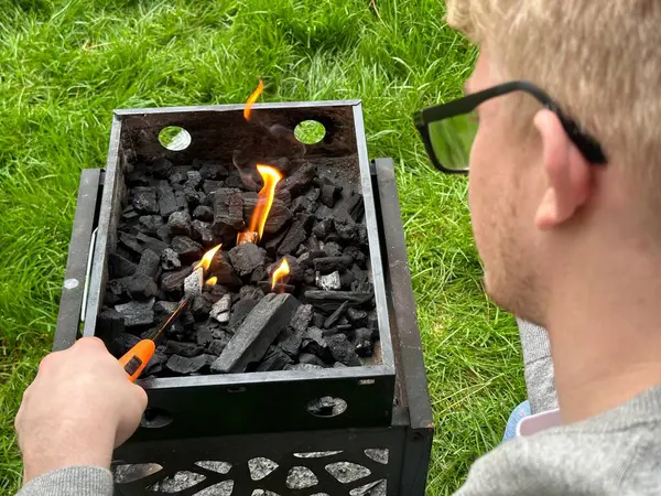 Cropped Shot Man Starting Fire Charcoal Grill Outdoors Stock Image