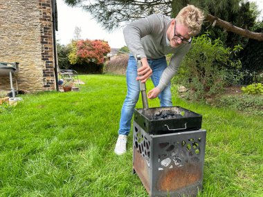 Yakışıklı bir delikanlının bahçesindeki portatif ızgarada yangın çıkardığı uzun bir çekim.