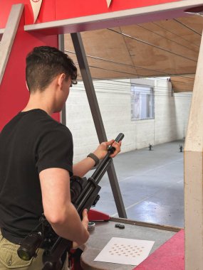 Havalı tüfeğini kuşanmış bir adamın dikey atışı.