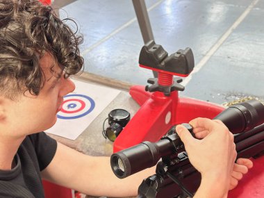 Adam ateş etmeden önce tüfeğini ayarlıyor.