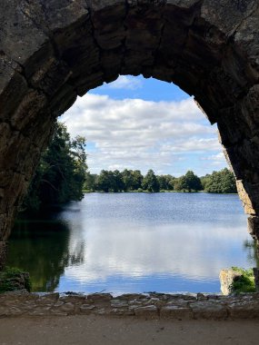 Güzel göl manzarası eski bir kemerli yapıdan görülebilir.