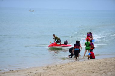 Mutlu insanlar muz teknesine binerken eğleniyor.