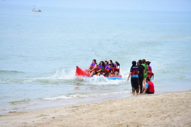 Mutlu insanlar muz teknesine binerken eğleniyor.