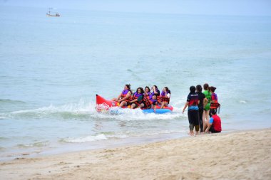 Mutlu insanlar muz teknesine binerken eğleniyor.