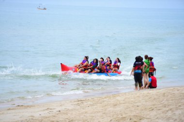 Mutlu insanlar muz teknesine binerken eğleniyor.