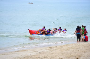 Mutlu insanlar muz teknesine binerken eğleniyor.