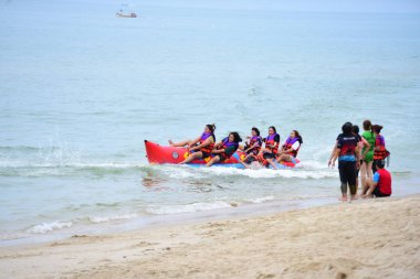 Mutlu insanlar muz teknesine binerken eğleniyor.