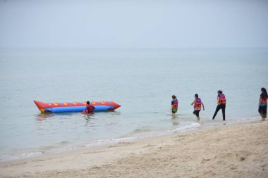 Mutlu insanlar muz teknesine binerken eğleniyor.