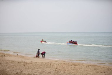 Mutlu insanlar muz teknesine binerken eğleniyor.