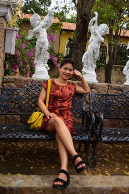 Parkta bankta oturan Asyalı kadın