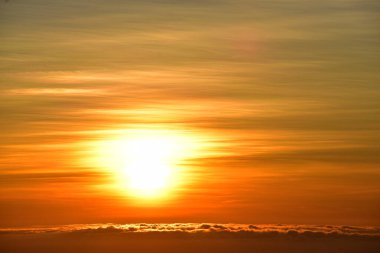 Gün doğumunda dağlarda güzel bir manzara. Bulutlu turuncu gökyüzü ve dağ sisi.