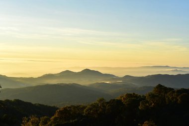 Güzel gökyüzü ve altın bulutlar, güneş doğmadan önce dağlar. Tepenin tepesinden bak..