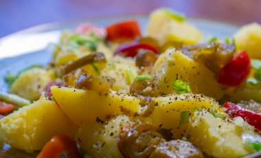 Baharatlı haşlanmış patateslerin, baharatlı acı biber dilimlerinin, canlı vişneli domateslerin ve lezzet patlaması için taze doğranmış taze soğanların enfes kombinasyonunun tadını çıkarın..