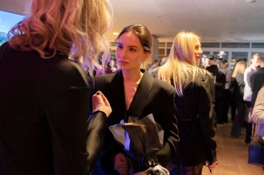 Kyiv, Ukrayna - 17 Şubat 2025. Gasanova defilesinin kulisinde konuklar, Ukrayna Moda Haftası sırasında sergilenen son tasarımlar hakkında fikir ve heyecan alışverişinde bulunuyorlar..