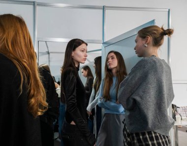 Kyiv, Ukrayna - 14 Şubat 2025. Ukrayna Moda Haftası FW25-26 sırasında sahne arkasında modeller ve stilistler etkileşime girer, giysileri hazırlar, makyajlarını ayarlar ve görünüşlerini tartışırlar..