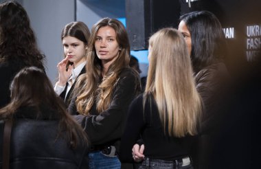 Kyiv, Ukrayna - 14 Şubat 2025: Moda Haftası 'nın ilk gününde heyecan havayı doldururken mankenler ve tasarımcılar sahne arkasında koşuşturuyor, giysileri hazırlıyor, saç ve makyajı ayarlıyor..