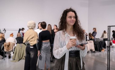 Kyiv, Ukrayna - 14 Şubat 2025. Mankenler ve tasarımcılar iş birliği yaparak havayı dolduruyor, son dakika ayarlamaları yapıyor ve gün içinde yapılacak podyum etkinliklerinden önce kahkahaları paylaşıyorlar..