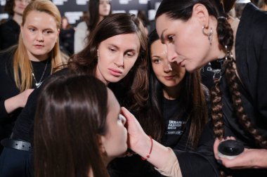 Kyiv, Ukrayna - 14 Şubat 2025: Ukrayna Moda Haftası FW25-26 'da sahne arkası, stilistler ve makyözler yoğun hazırlıklara girişirler, her detay modellerin çarpıcı görünümünü artırır..