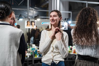 Kyiv, Ukrayna - 14 Şubat 2025: Modeller ve stilistler moda haftasının hareketli başlangıcında vizyonları gerçeğe dönüştürürken neşe içinde kahkahalar hazırlayıp paylaşıyorlar.