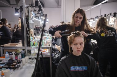 Kyiv, Ukrayna - 14 Şubat 2025: Ukrayna Moda Haftası 'nın sahne arkası, kuaförler ve makyözler modeller üzerinde tutkuyla çalışıyorlar, heyecan verici bir atmosfer yaratıyorlar..