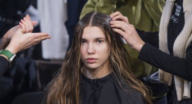 Kyiv, Ukrayna - 14 Şubat 2025: Enerji, kulis alanını modellerin saçı üzerinde titizlikle çalışırken, onları podyuma hazırlıyor.