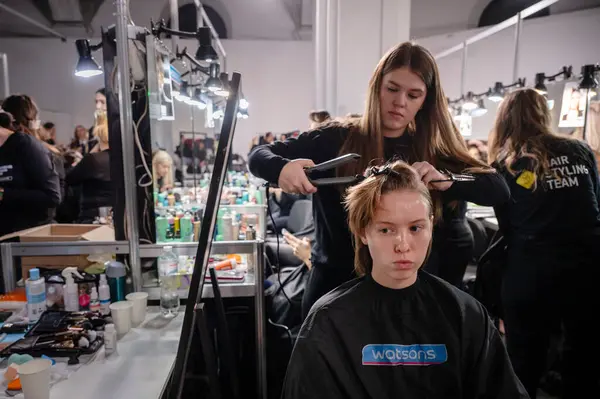 Kyiv, Ukrayna - 14 Şubat 2025: Ukrayna Moda Haftası 'nın sahne arkası, kuaförler ve makyözler modeller üzerinde tutkuyla çalışıyorlar, heyecan verici bir atmosfer yaratıyorlar..