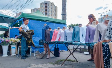 Kyiv, Ukrayna - 2 Nisan 2025: Canlı bir sokak pazarı, şehir sakinlerinin canlı günlük yaşamlarını yansıtan giysi ve çiçek düzenlemeleri sergileyen yerel esnaflara ev sahipliği yapıyor..