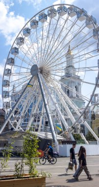 Ukrayna 'nın Ukrayna bayrağının gururla sergilendiği Ukrayna' nın Kyiv kentindeki tarihi binaların zeminine karşı dik duran büyük beyaz dönme dolap boş zamanların ve ulusal gururun özünü yakalıyor.