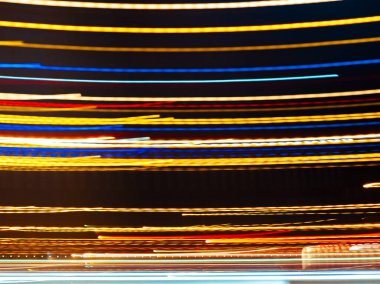 Karanlık arka plana karşı dinamik desenler oluşturan parlak ışık izleri, hareket ve enerji gösteriyor