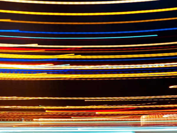 Karanlık arka plana karşı dinamik desenler oluşturan parlak ışık izleri, hareket ve enerji gösteriyor