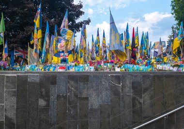 Kyiv, Ukrayna - 25 Temmuz 2025: Kyiv 'de Meydan Nezalezhnosti' ye el sallayan Ukrayna ve yabancı bayraklar, Rusya-Ukrayna savaşının kaybettiği kahramanlarını onurlandırıyor, çiçekler ve portrelerle çevrili