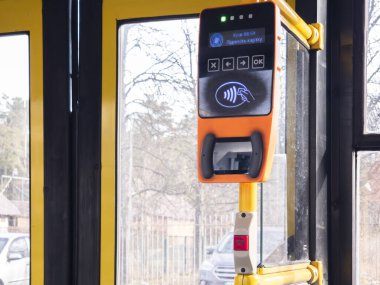 Kyiv, Ukrayna -6 Mart 2025: Ukrayna 'da toplu taşımacılıkta kredi kartı kabul eden temassız ödeme terminali, sarı kapılar ve bulanık kentsel zemin