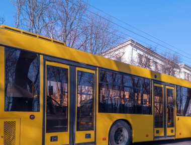 Kyiv, Ukrayna -6 Mart 2025: Sarı toplu taşıma otobüsü Ukrayna 'da güneşli bir kış gününde şehirde sürüş yapıyor ve uygun kentsel hareketlilik sunuyor