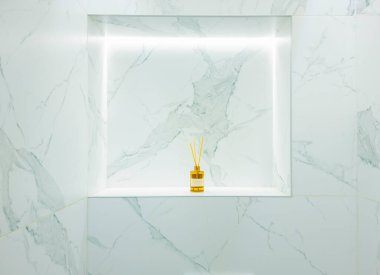 Reed difüzörü modern bir banyoda dinleniyor, zarif mermer fayansların üzerine sıcak bir parıltı saçıyor ve rahatlamak için mükemmel, sakin, lüks bir atmosferi geliştiriyor.