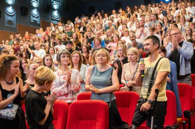 Kyiv, Ukrayna, 31 Ağustos 2025. Seyirci, yönetmenle konuşurken protez bacaklı ve koltuk değnekli bir Ukraynalı gaziyi alkışlıyor.