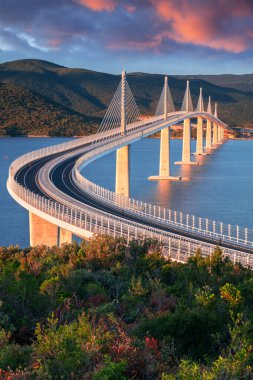 Peljesac Köprüsü, Hırvatistan. Hırvatistan 'ın Dubrovnik-Neretva İlçesi' nde güneş doğarken deniz üzerindeki Peljesac Köprüsü 'nün çok açıklıklı güzel bir görüntüsü.