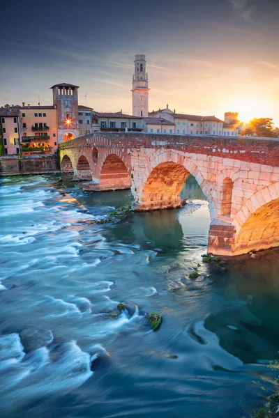 イタリアのヴェローナ 美しいイタリアの町の風景画像日没時にアディジェ川にかかる石の橋とヴェローナ — ストック写真