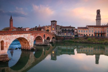 Verona, İtalya. Güzel İtalyan kasabası Verona 'nın şehir manzarası. Gün batımında Adige Nehri üzerindeki Taş Köprü ile birlikte..