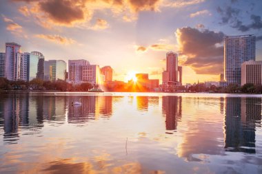 Orlando, Florida, ABD. Orlando, Florida 'nın şehir manzarası güzel gün batımında şehrin ufuk çizgisinin yansımasıyla..