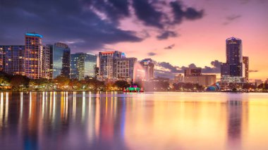 Orlando, Florida, ABD. Orlando, Florida 'nın şehir manzarası güzel gün batımında şehrin ufuk çizgisinin yansımasıyla..