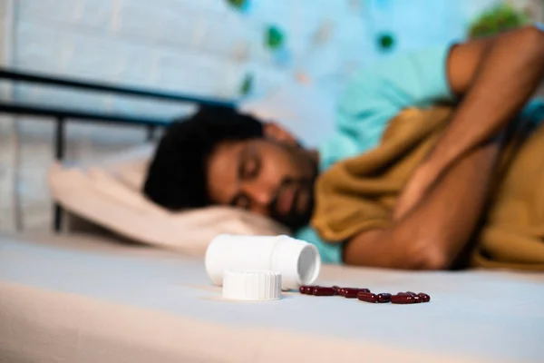 夜のベッドの上で錠剤や薬の丸薬で深い眠りに若い男 不眠症の薬の概念 不健康なライフスタイルと中毒 — ストック写真