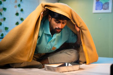 Hasta adam öksürükten kurtulmak için mentollü buhar soluyor. Ağrı kesici, ev hapları, terapi..