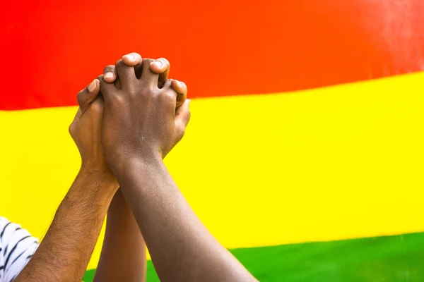 Close up shot group of hands joining in front of black history month flag - concept of unity, support and confident.