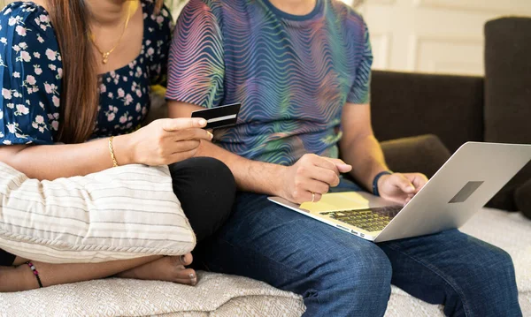 Close up shot of couple making online payment for shopping using credit card on laptop at home - concept of secure transaction, ecommerce and finance.