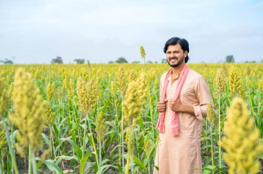 Confident young farmer standing by looking at camera at farmland - concept of successful, agriculture and modern farming