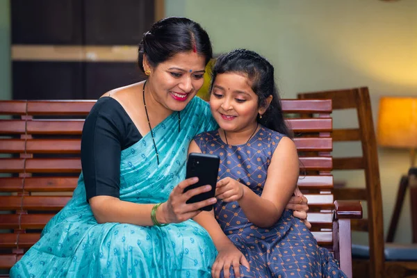 Щаслива Мати Показує Мобільний Телефон Дочці Сидячи Дивані Вдома Концепція — стокове фото