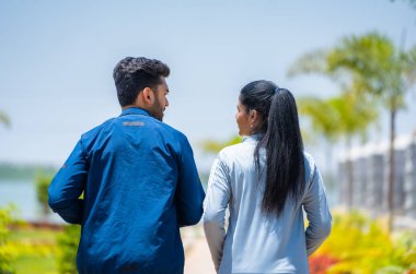 Arka planda koşan ya da parkta koşan çiftlerin görüntüsü - sağlıklı yaşam tarzı, sabah rutini ve birliktelik kavramı.